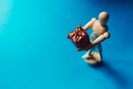 Wooden hinged Mannequin with Christmas gift on the blue backgroundの写真素材