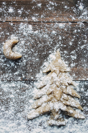 Christmas tree and moon with flour on the wooden tableの写真素材