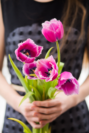 Woman holding beautiful bouquet with tulpins in summerの写真素材