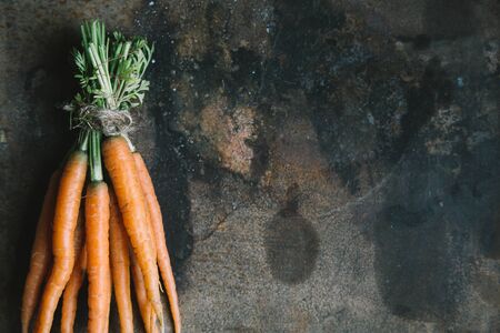 Bunch of fresh carrots on old grunge rusty backdrop, top view, copy spaceの写真素材
