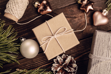 Gifts, Christmas decorations, fir branches and cones on the dark brown wooden background, Christmas preparation concept, top viewの写真素材