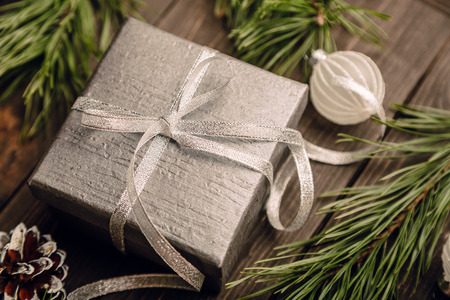 Gifts, Christmas decorations, fir branches and cones on the dark brown wooden background, Christmas preparation concept, top viewの写真素材
