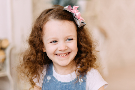 Laughing girl with curly hair in studioの写真素材