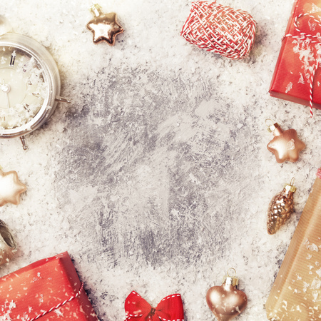 Frame from christmas decoration, toys and gifts on snowy grey background, top view, copy spaceの写真素材