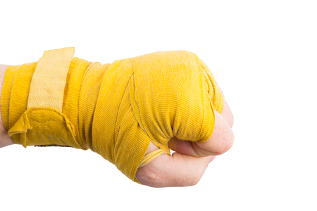 Boxer fist in battered yellow bandage on isolated white background. Power and purposefulness conceptの写真素材
