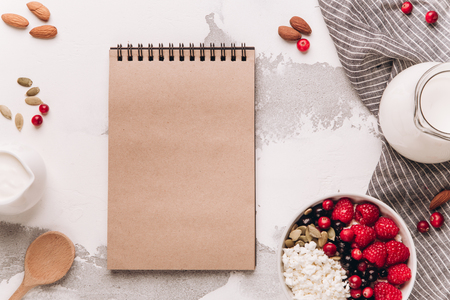 Cottage cheese with frozen raspberries, currants, almonds, pumpkin seeds and milk on rustic background. Healthy breakfast concept. Copy spaceの写真素材