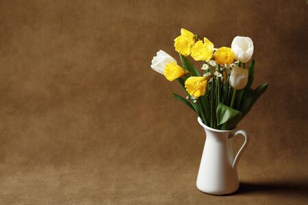 Spring bouquet of daffodils and tulips on canvas. Floral background, copy spaceの写真素材