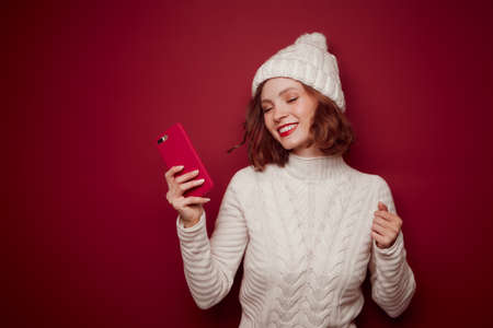 Happy smiling woman in sweater hold phoneの写真素材