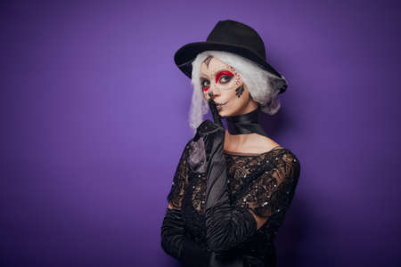 Cheerful young woman in Halloween costume whisperingの写真素材