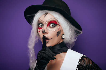 Scared whispering woman with grey hair in Halloween costumeの写真素材