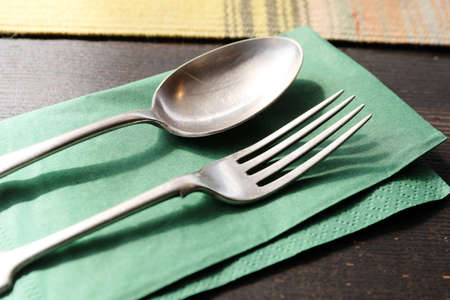 Spoon and fork on napkin on wooden table close-upの写真素材