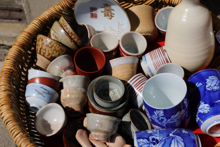 Ceramic tableware in a basket on a street market.