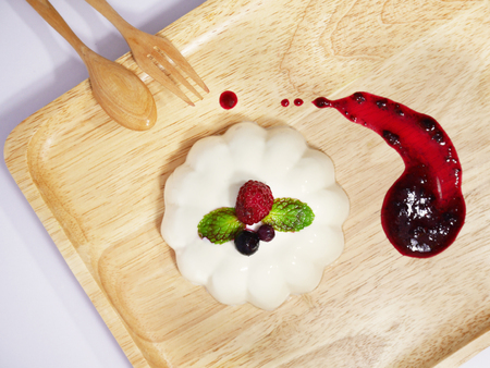 Panna Cotta with mixed berries sauce on wood trayの写真素材