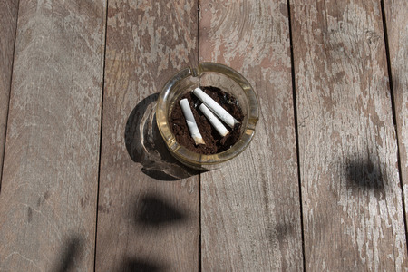 Smoking and then placed in an ashtray.on wood backgroundの写真素材