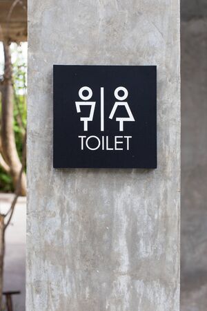 Unisex restroom or toilet and arrow sign on concrete wallの写真素材