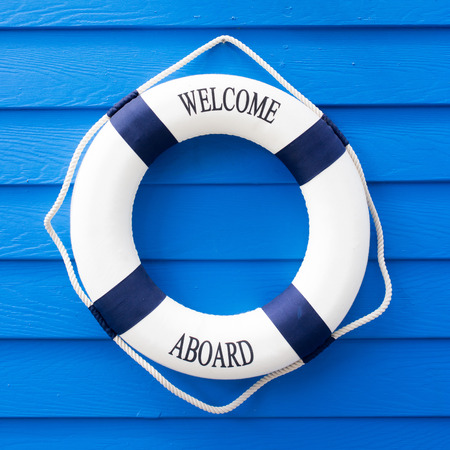 White Life buoy with welcome aboard on blue wallの写真素材