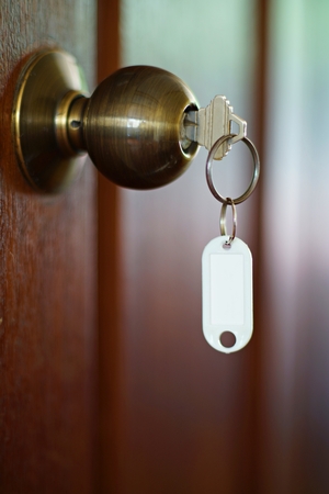 House key with home keyring in keyhole, property concept, empty tagの写真素材