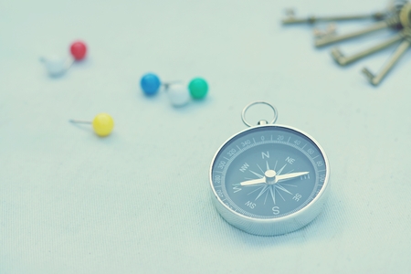Compass and marking pins on white canvas background, copy spaceの写真素材