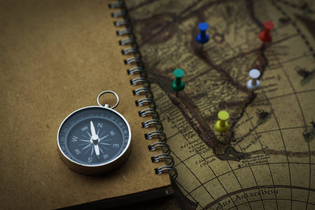 Compass and notebook on blur vintage world map, journey concept, copy spaceの写真素材