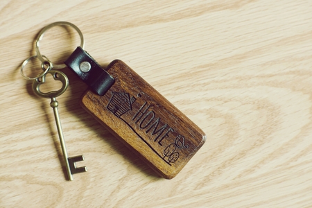 Vintage house keys and wood home keychain on wooden table background, key conceptの写真素材
