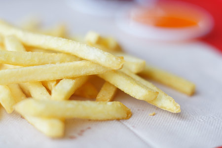 French fries on white paper background, unhealthy food concept