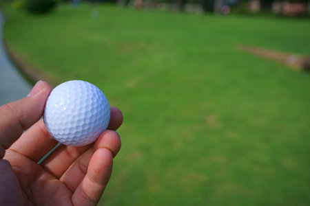 Golf ball and tee on golf green course background, copy spaceの写真素材