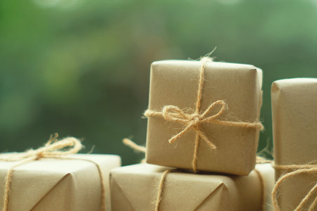 Simple eco friendly gift boxes package wrap with brown paper on vintage wooden table, green present...