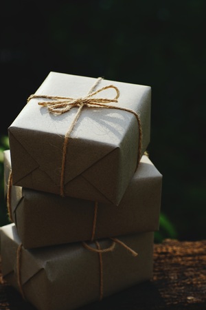 Simple eco friendly gift boxes package wrap with brown paper on vintage wooden table, green present concept, copy spaceの写真素材