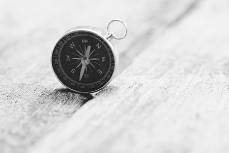Retro compass on vintage wooden table background with smooth blur background, copy spaceの写真素材