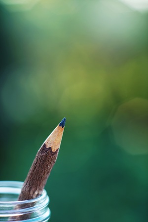 Handcraft pencil made of wood in glass bottle with smooth blur green garden background, copy spaceの写真素材