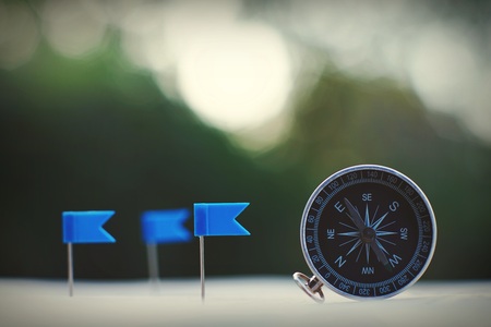Compass and flag pins on blur vintage world map, journey concept, copy spaceの写真素材