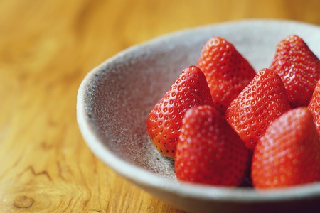 Lovely red fresh ripe strawberry in bowl on wooden table, copy space, eleganceの写真素材