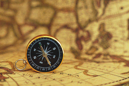 Compass on blur vintage map background, retro color tone, direction journey planning concept, copy...