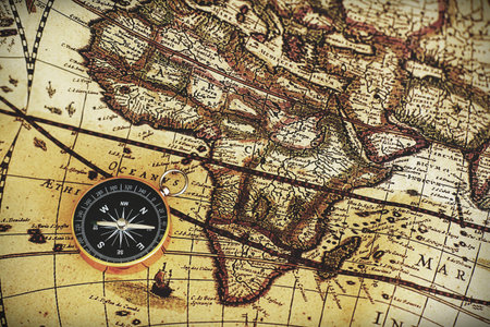 Compass on blur vintage map background, retro color tone, direction journey planning concept, blank...