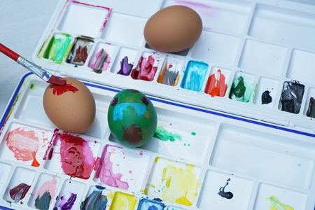 Colorful easter eggs painting activity with color tray background, fun event for kid concept, copy spaceの写真素材