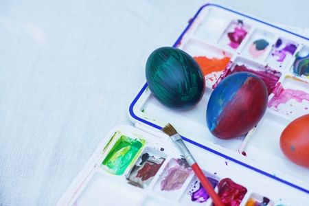 Colorful easter eggs painting activity with color tray background, fun event for kid concept, copy spaceの写真素材