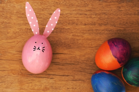 Easter egg painted into bunny face with long and fold ear, Easter holiday concept, fancy eggs, copy spaceの写真素材