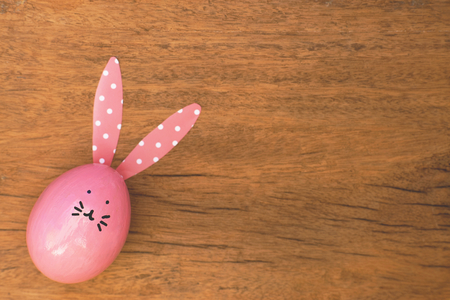 Easter egg painted into bunny face with long and fold ear, Easter holiday concept, fancy eggs, copy spaceの写真素材