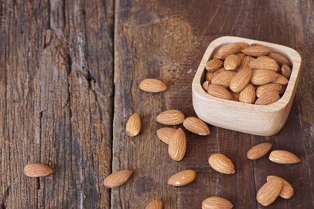Almond nut in wooden bowl on classic wooden table background, copy spaceの写真素材