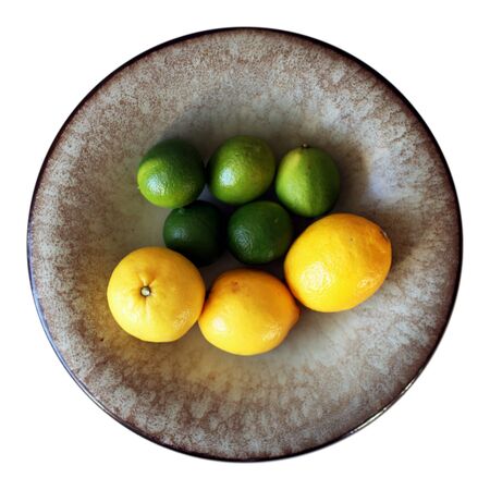 Five limes and three lemons in a clay bowlの写真素材