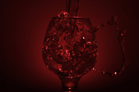 Abstract composition for designers with bar glass for cognac and flow jet of spirit with flash sparksの写真素材