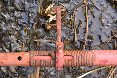 Abstract image look for designers with fragment of pipe in the stone wall near rusty pondの写真素材