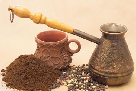 Abstract figure photography for editors, designers and artists with copper coffee pot, pile of coffee, pepper and little clay cupの写真素材