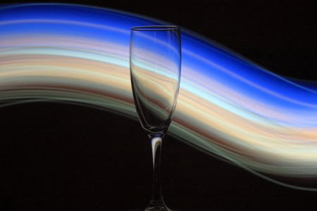 Night photo of champagne glass with bright lights and sparks on the backgroundの写真素材