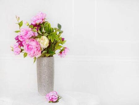 Pink flowers in silver vase on white wall background. 8 March. Happy women's day.の写真素材