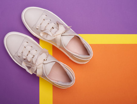 A close-up view of comfortable casual beige sneakers on a three-colored background. Shoe advertising conceptの写真素材