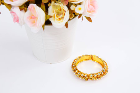 Golden bracelet with diamonds and flowerpot on white backgroundの写真素材