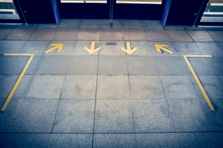 Arrow sign on floor at the sky train stationの写真素材