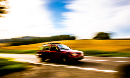 A car speeding down the road that is blurred.の写真素材