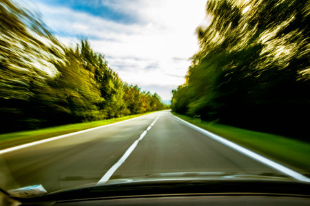 A car speeding down the road that is blurred.の写真素材